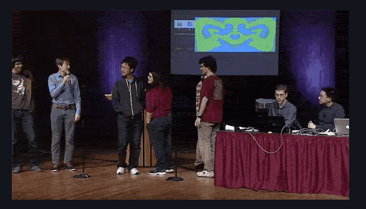 A group of people standing on a stage

Description automatically generated